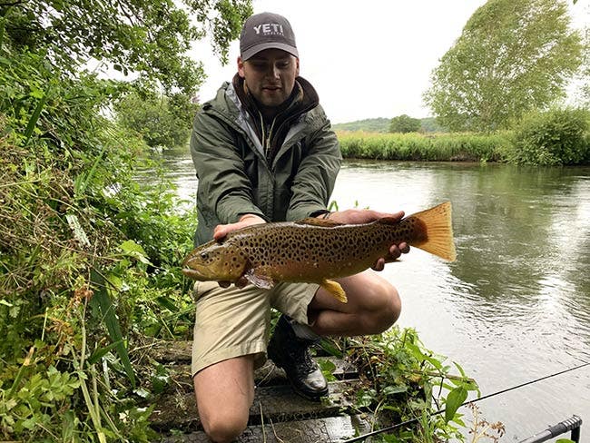 Jack with a brown trout Jack pictured on the riverbank with a stunning brown trout