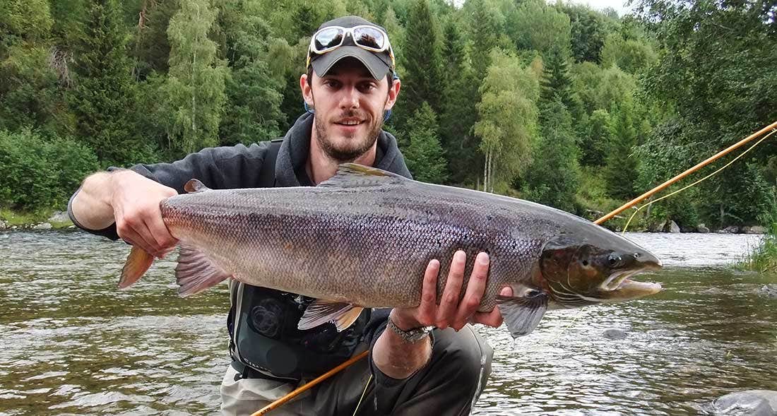 Man holding salmon in the river before releasing
