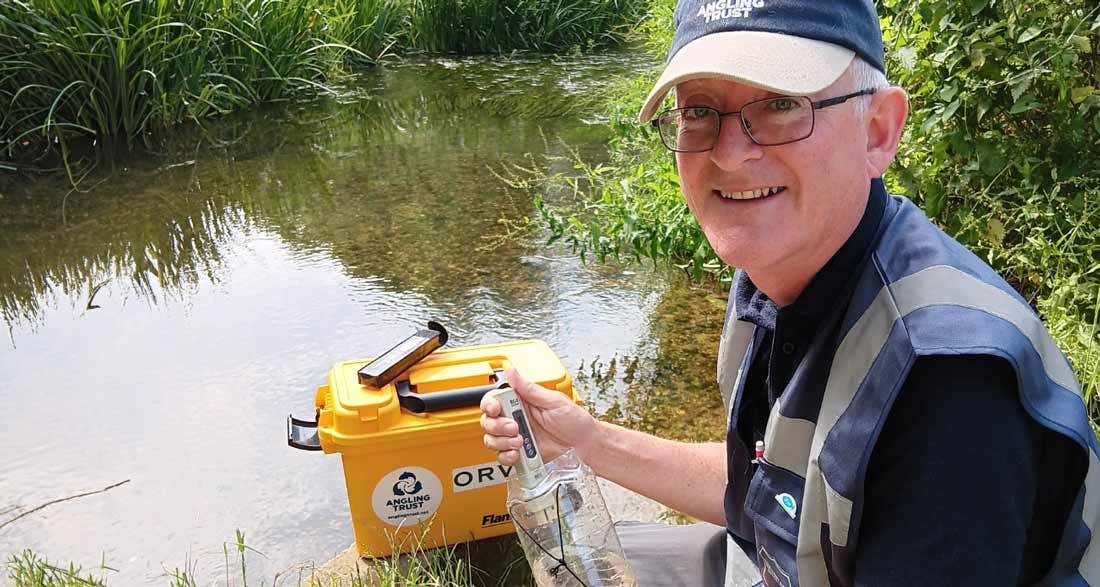 Water Quality monitoring volunteers Water Quality monitoring volunteer sat on a rock by the river conducting tests