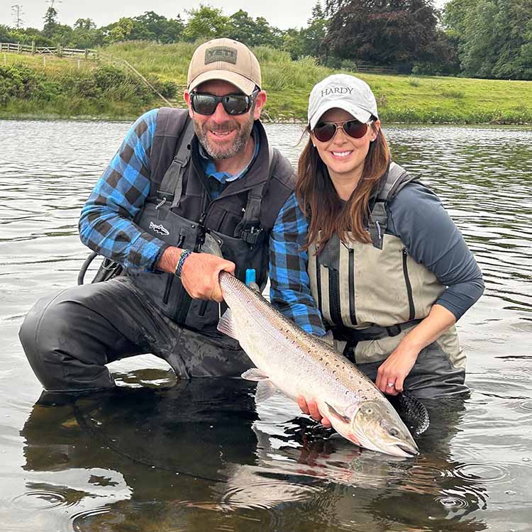 Lucy and her guide with salmon in the water Lucy and her guide with salmon in the water