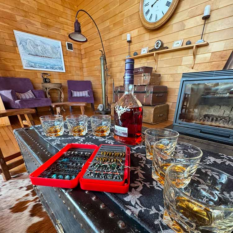 Fly boxes with prepared sea trout flies Fly box on the bar with sea trout flies inside, and whiskey poured